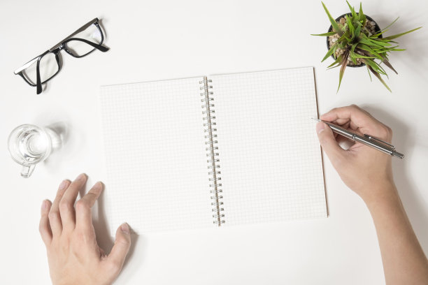 一个人要在他的笔记本上写些东西。俯视图，平铺。图片下载