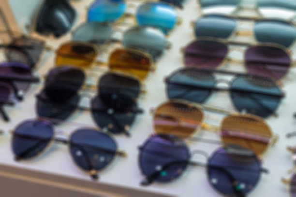 迷离的太阳镜店用眼镜和不同的衣服为人们的眼睛戴上紫外线保护太阳。各种形状和大小的玻璃。图片下载