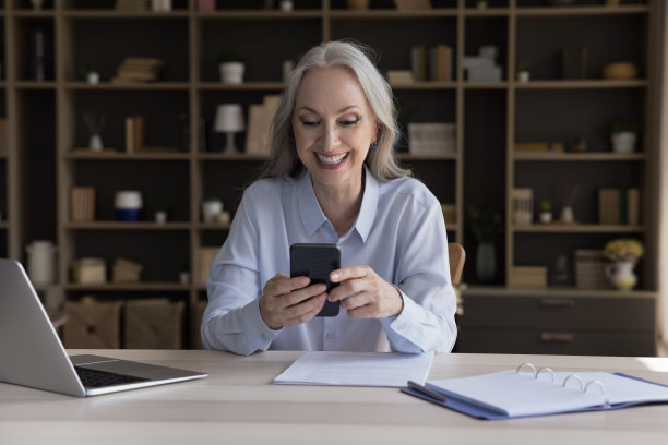 快乐成熟的智能手机用户女性阅读信息图片下载