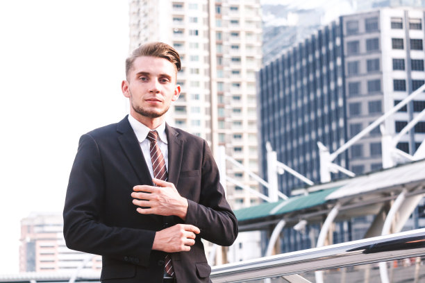 穿着黑色西装站在户外的英俊男子的肖像图片下载