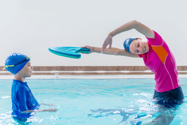 男孩在教练的指导下上游泳课图片下载