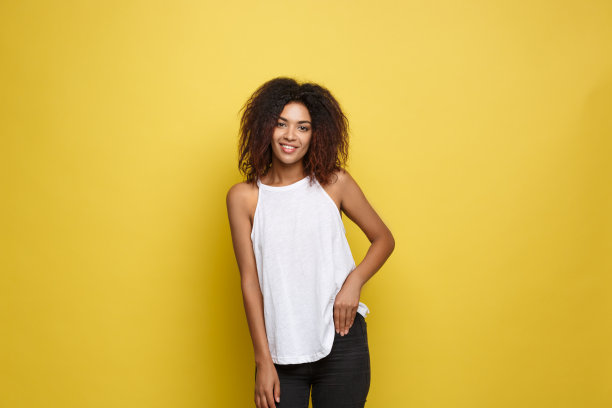 美丽迷人的非洲裔美国女人，戴着时髦的眼镜，在黄色的工作室背景下张贴。副本的空间。图片下载