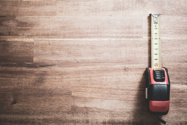 实心卷尺与拉出的规模躺在右边的木桌，自上而下的看法图片下载