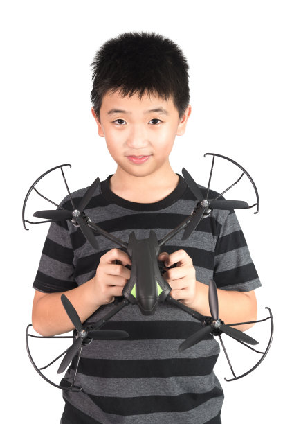亚洲男孩手里拿着无人机玩具，孤立在白色背景上。图片下载