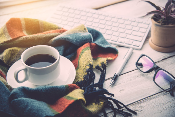 咖啡杯和围巾放在白色的木地板上。图片下载