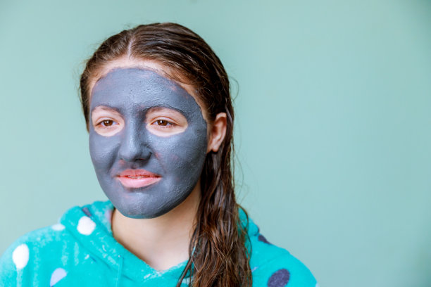 敷面膜的Spa女士。美容。一个漂亮女孩的特写，她头上缠着毛巾敷着面膜图片下载