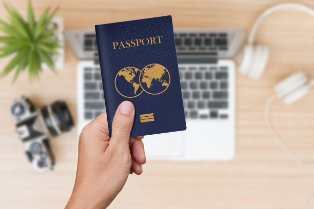 手里拿着蓝色护照，背景是旅行用品图片下载