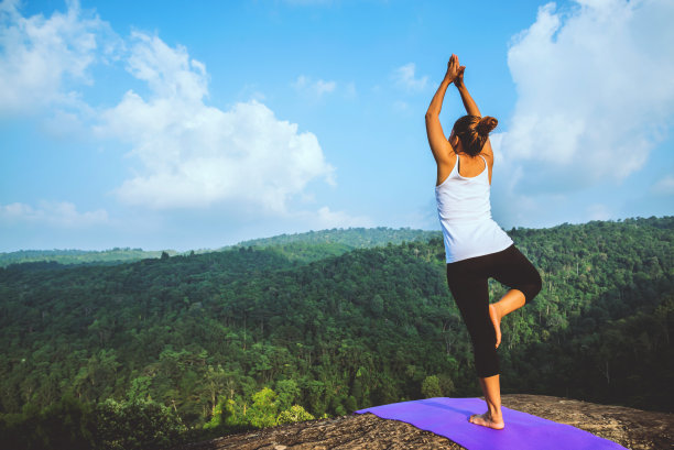 亚洲女人在假期放松。旅行放松。练习瑜伽。在山岩峭壁上。泰国山林的性质图片下载