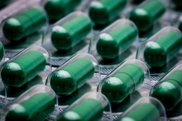 穿心莲提取物治疗感冒、咽喉痛。标准化草药胶囊，包装。全框绿色胶囊药片。替代医学概念。图片下载