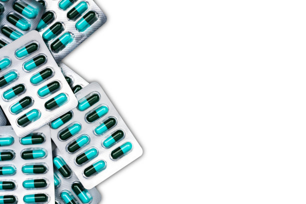 蓝色和绿色抗生素胶囊药丸在吸塑包装隔离白色背景与复制空间的顶视图。抗菌药物耐药和合理使用抗生素的概念。图片下载