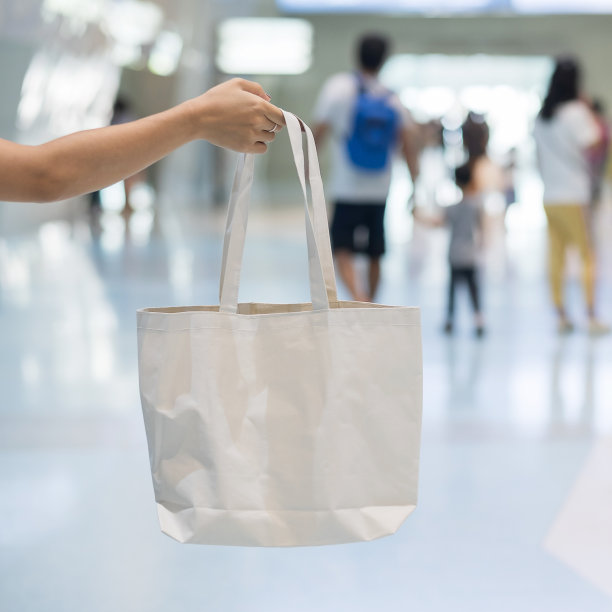 妇女手持环保购物袋在商店背景与文字复制空间。环境保护，零浪费，可重复使用，无塑料，世界环境日和地球日的概念图片下载