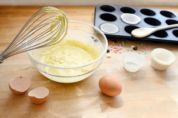 用蛋糕面团、鸡蛋壳和松饼模在厨房的木板上搅拌，烘焙概念图片下载