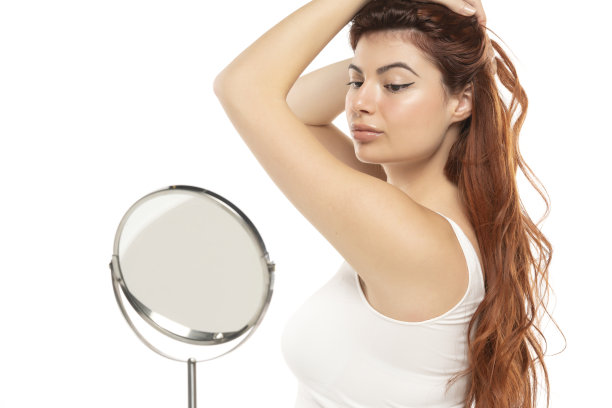 年轻的红发美女，皮肤清新，在白色背景的镜子里看着自己图片下载
