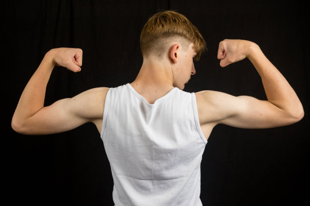 十几岁的男孩从后面弯曲他的手臂图片下载