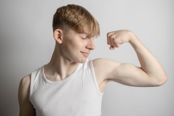 十几岁的男孩在弯曲他的二头肌图片下载