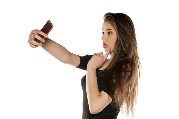 一个留着长发的年轻女孩在白色背景上自拍图片下载