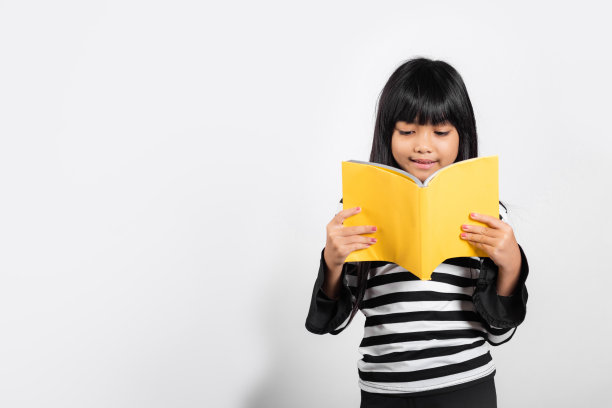 亚洲小孩10岁拿着和阅读黄色的书图片下载