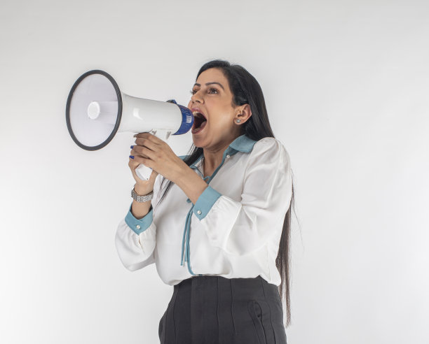穿着职业服装的女性站在白色背景下对着扩音器尖叫图片下载