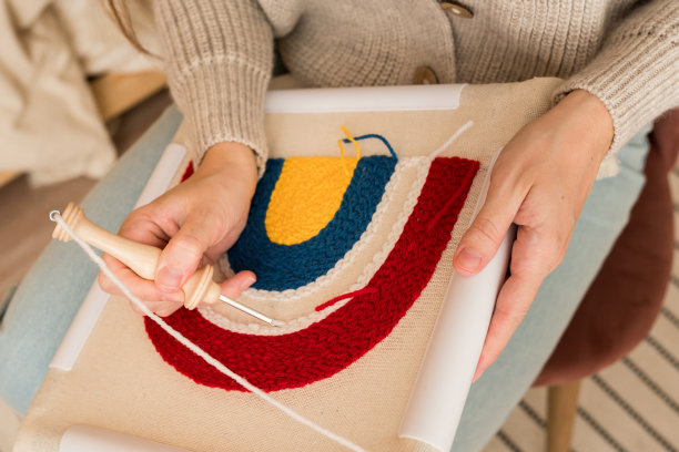 绣花打孔针的新趋势。妇女为家庭创造手工装饰的特写。女性将穿刺针直接推入织物。爱好，DIY，手工概念图片下载