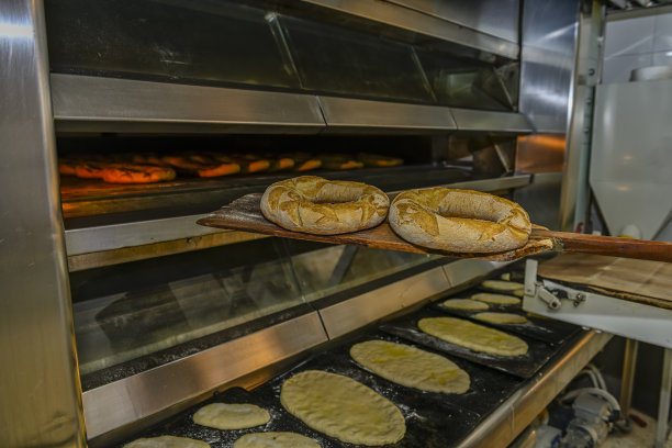 新鲜出炉的面包在传统的烤箱门。图片下载