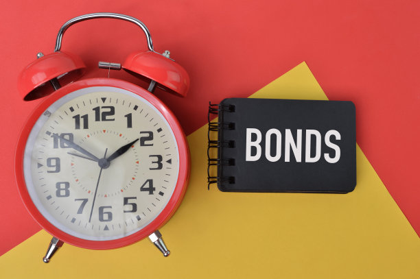 时钟和笔记本上写的文字债券。前视图。图片下载