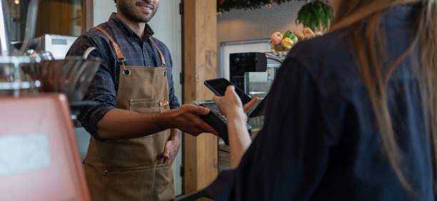 一名女子在咖啡厅餐厅用智能手机扫描二维码进行数字支付，无需现金。选择菜单和订单累积折扣。电子钱包，科技，在线支付，信用卡，银行应用。图片下载