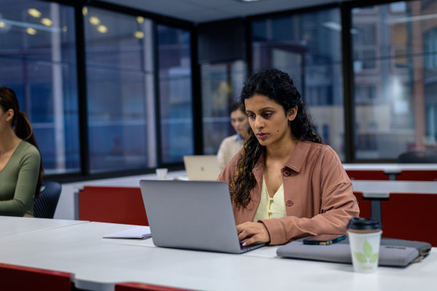 年轻的成人学生在教室里通过电脑学习图片下载