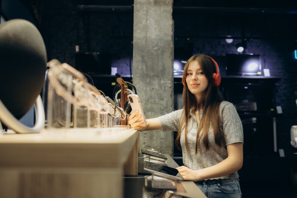 可爱时尚的快乐女孩在科技商店里测试和选择耳机的特写图片下载