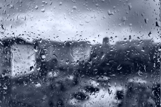 城里的坏天气。建筑物，房子，窗外的汽车。云量:积云。气象学和天气预报。雨滴顺着玻璃流下来。城市街道上狂风暴雨图片下载