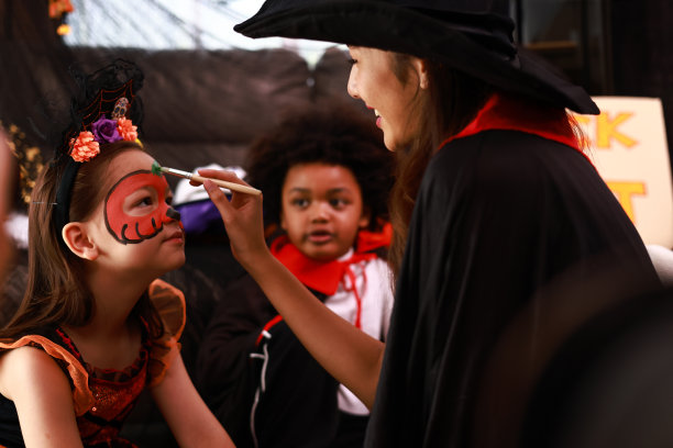 男孩和女孩在一个有万圣节装饰的房间里玩得很开心。图片下载