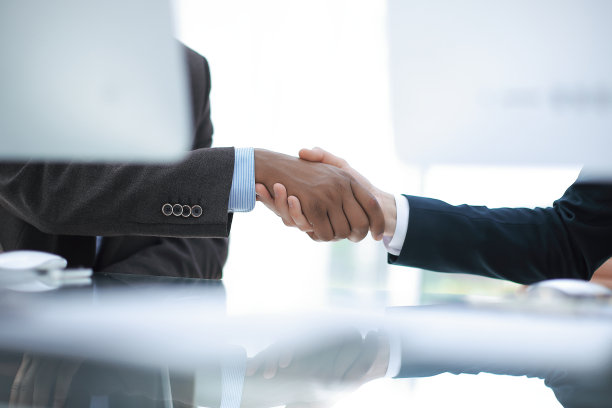 办公桌上方商业伙伴握手的背景图片图片下载