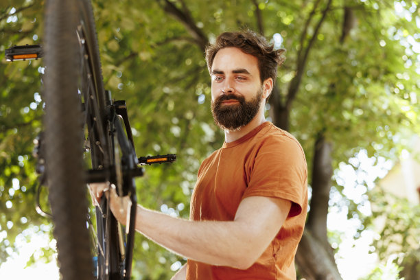 男子检查自行车零件是否损坏图片下载