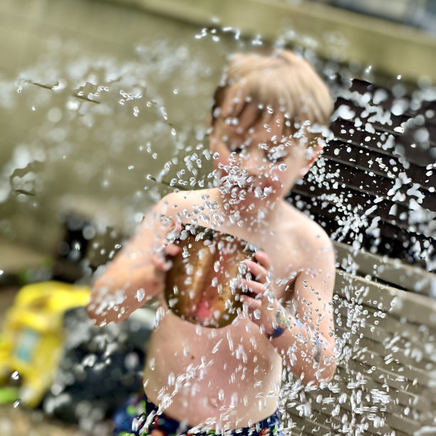 小男孩在洒水车里保持凉爽图片下载