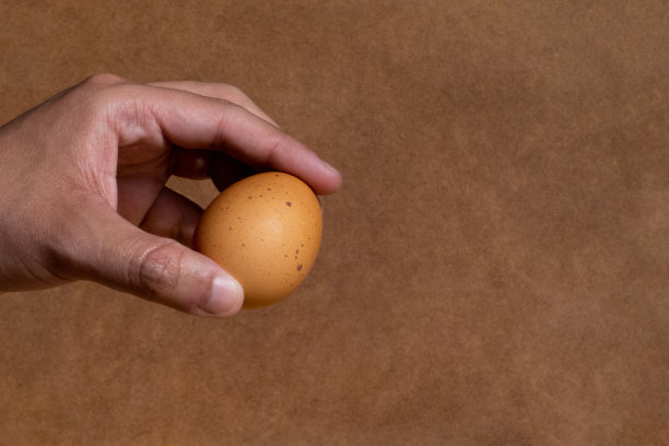 一个男人用手指握着一个鸡蛋图片下载