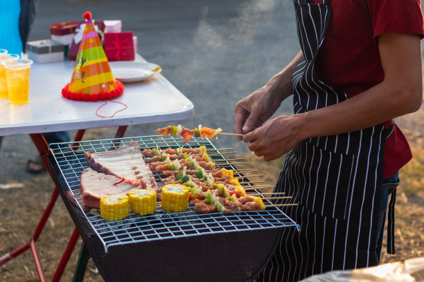烧烤聚会用的肉和串料放在烤架上烤烧烤，为今晚家人参加烧烤聚会做好准备。派对背景图片有文本的复制空间。图片下载