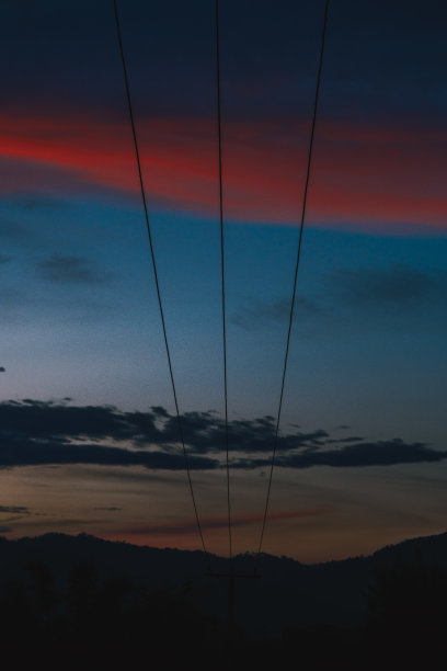 日落时天空中引人注目的橙色云-天空背景中的云-电线图片下载