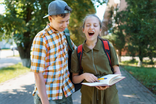 一个十几岁的男孩和一个十几岁的女孩正在打呵欠，厌倦了学习，想睡觉，夏日的城市街道图片下载