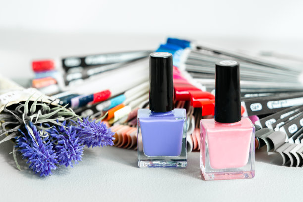 许多装着各种颜色指甲油样品的调色板和瓶子。粉色，紫色，法式美甲。美容院的专业美甲师。美甲服务，手部护理，手指护理图片下载