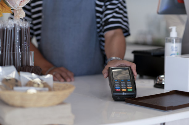 咖啡师在咖啡店接受信用卡支付，智能手机支付应用程序，在线支付。图片下载