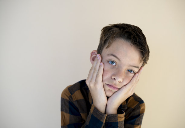 棕色背景下格子衬衫的酷男孩图片下载