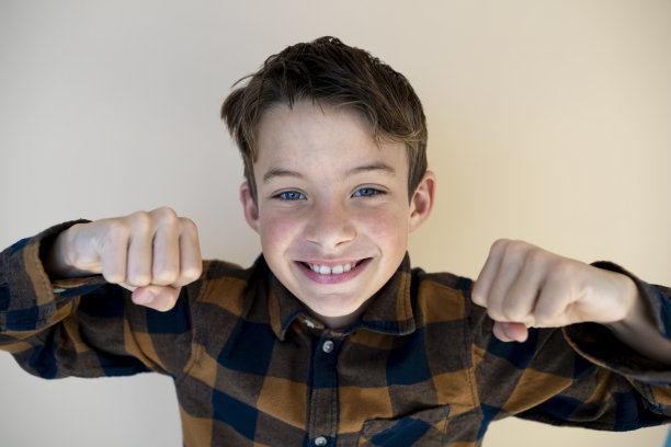 棕色背景下格子衬衫的酷男孩图片下载