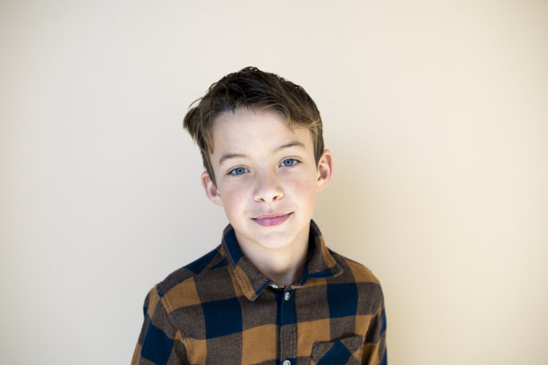 棕色背景下格子衬衫的酷男孩图片下载