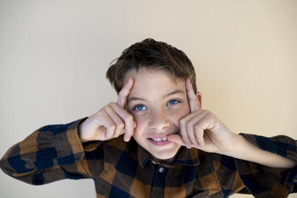 棕色背景下格子衬衫的酷男孩图片下载