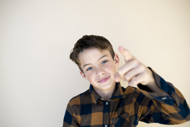 棕色背景下格子衬衫的酷男孩图片下载