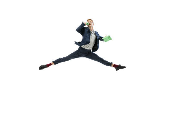 在办公室风格的衣服跳跃和使用老式电话孤立在白色工作室背景。商业、创业、开放空间、灵感概念。图片下载