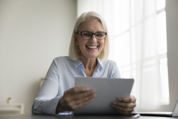 开朗的高级商务专业女性戴着眼镜拿着文件图片下载