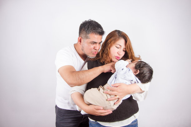 爸爸妈妈抱着孩子的漂亮照片。图片下载