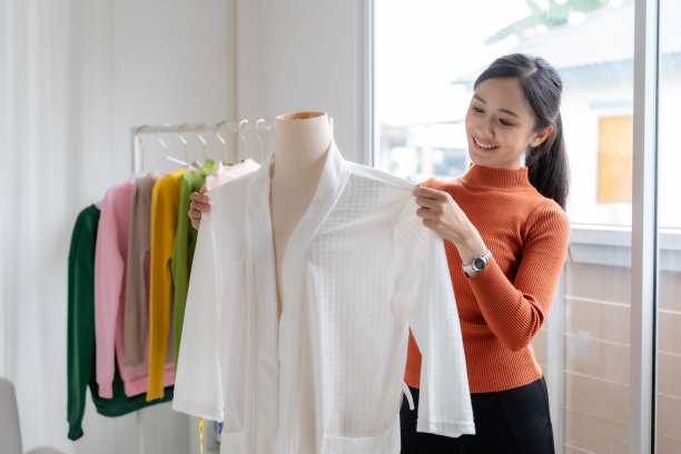 快乐的亚洲女设计师裁缝在时装工作室与卷尺。时尚设计理念图片下载