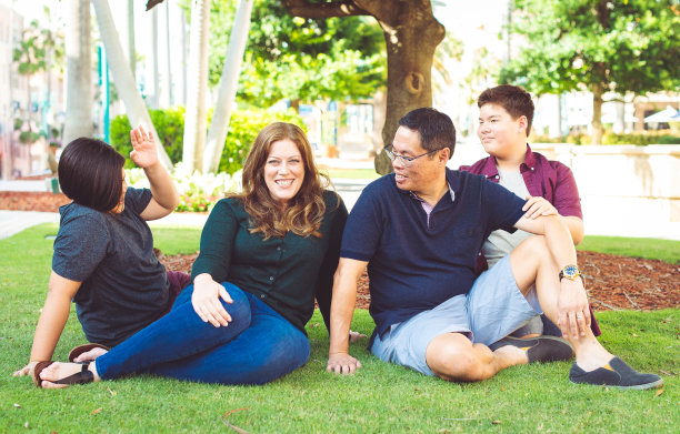 多种族亚裔美国家庭和十几岁的孩子一起在户外草地上的偷拍照片图片下载