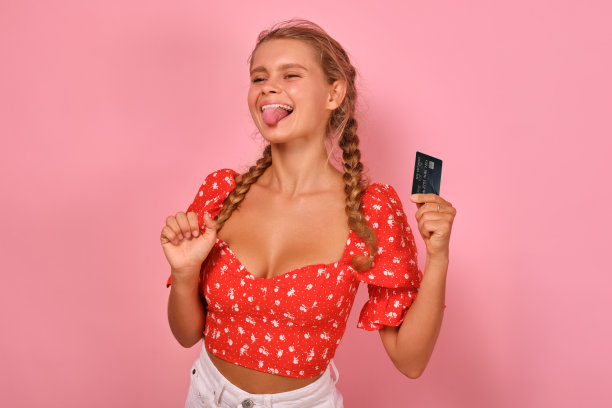 年轻可爱的白人少女手里拿着信用卡露出舌头图片下载